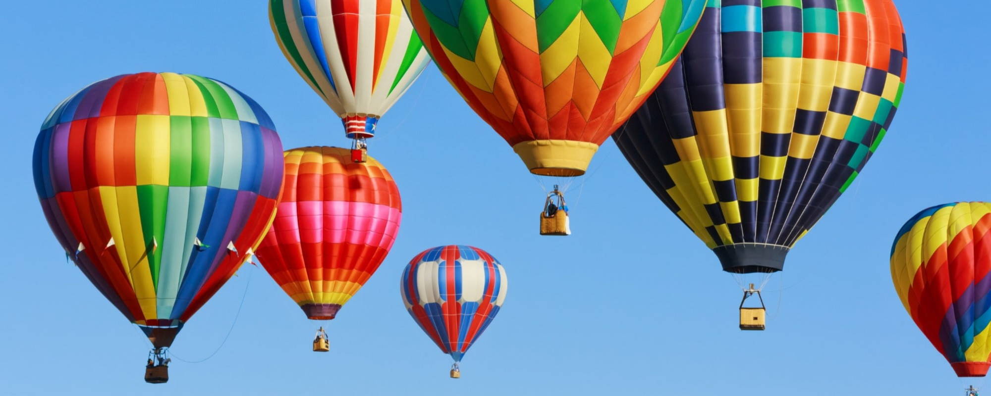 Brightly coloured hot air balloons against the sky